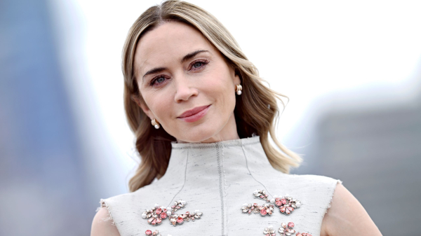 Emily Blunt appears at an event in a highnecked dress.